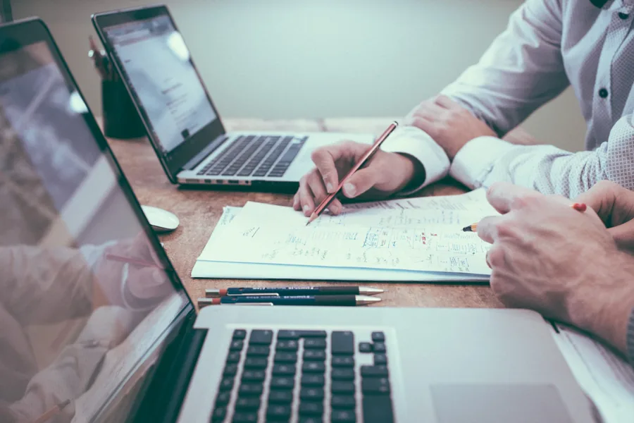 Analyst reviewing compliance documents on a laptop